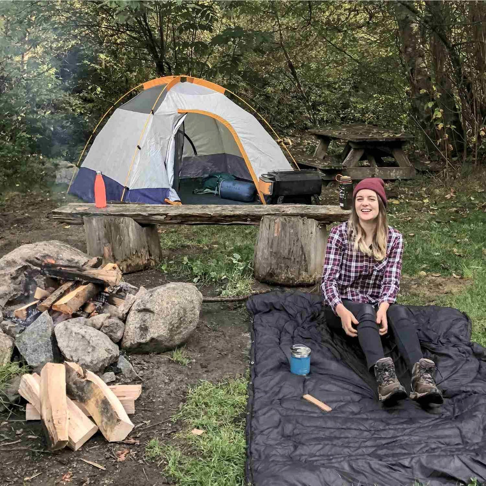 
                  
                    Woman camping outdoors with her 2-in-1 travel pillow blanket
                  
                