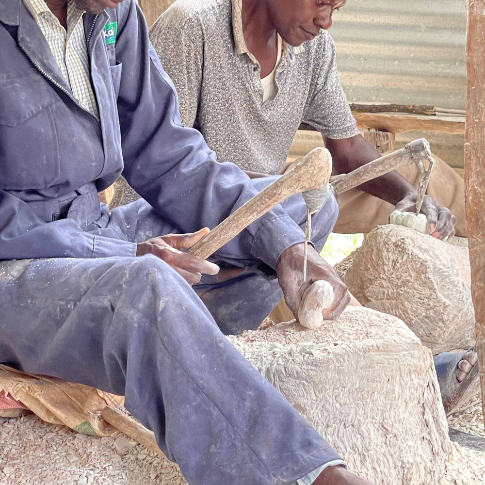 
                  
                    Two men working with sheep wool in a rustic setting
                  
                