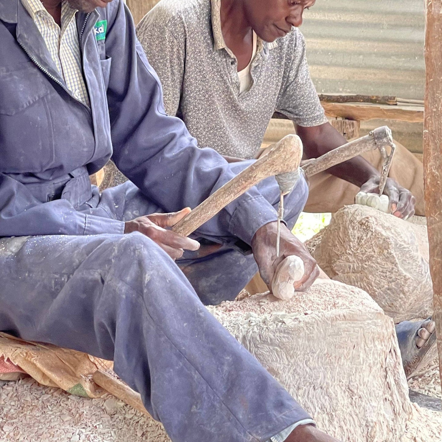 
                  
                    Two men working with sheep wool in a rustic setting
                  
                