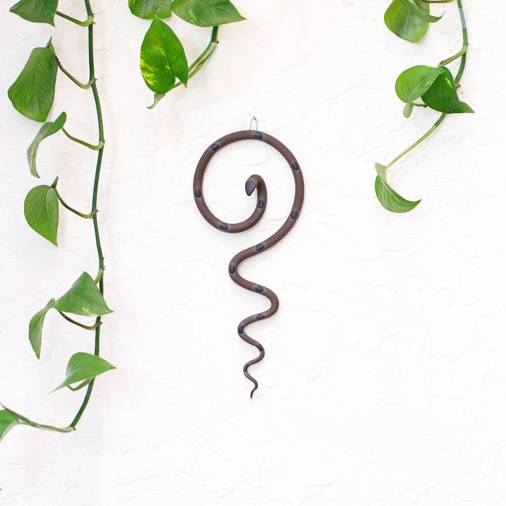 
                  
                    Ceramic snake art hanging on a wall in chocolate with dark spots
                  
                