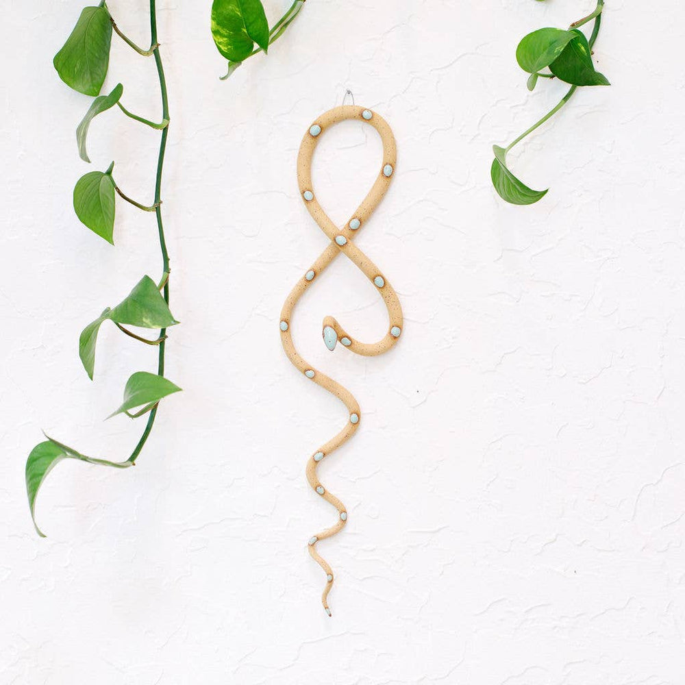 Ceramic snake wall art in light brown with mint spots