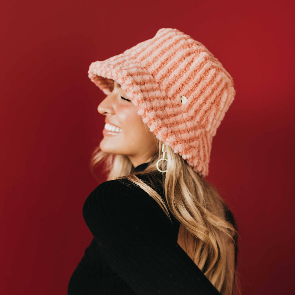 Woman wearing a chunky corduroy bucket hat with pink stripes