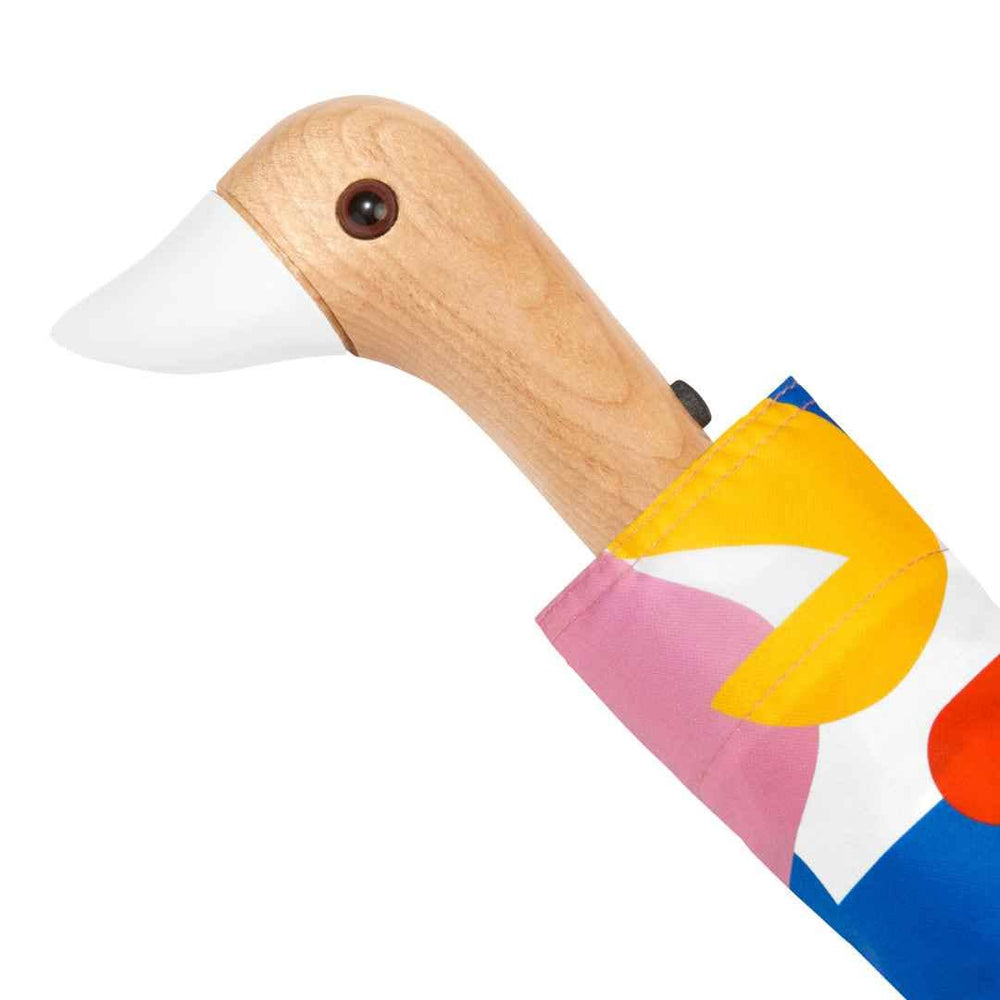 
                  
                    Close view of the duck head handle on the original duckhead umbrella. The colorful umbrella has a hand crafted wooden duck handle with a white beak.
                  
                