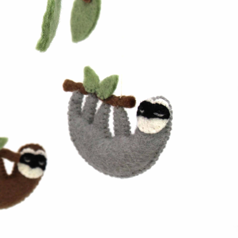 
                  
                    Close up of gray hanging sloth on the felt crib mobile
                  
                