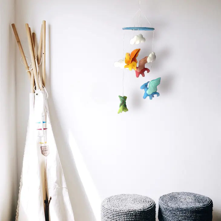 Felt nursery mobile with colorful felt dragons hanging in a little boy's bedroom