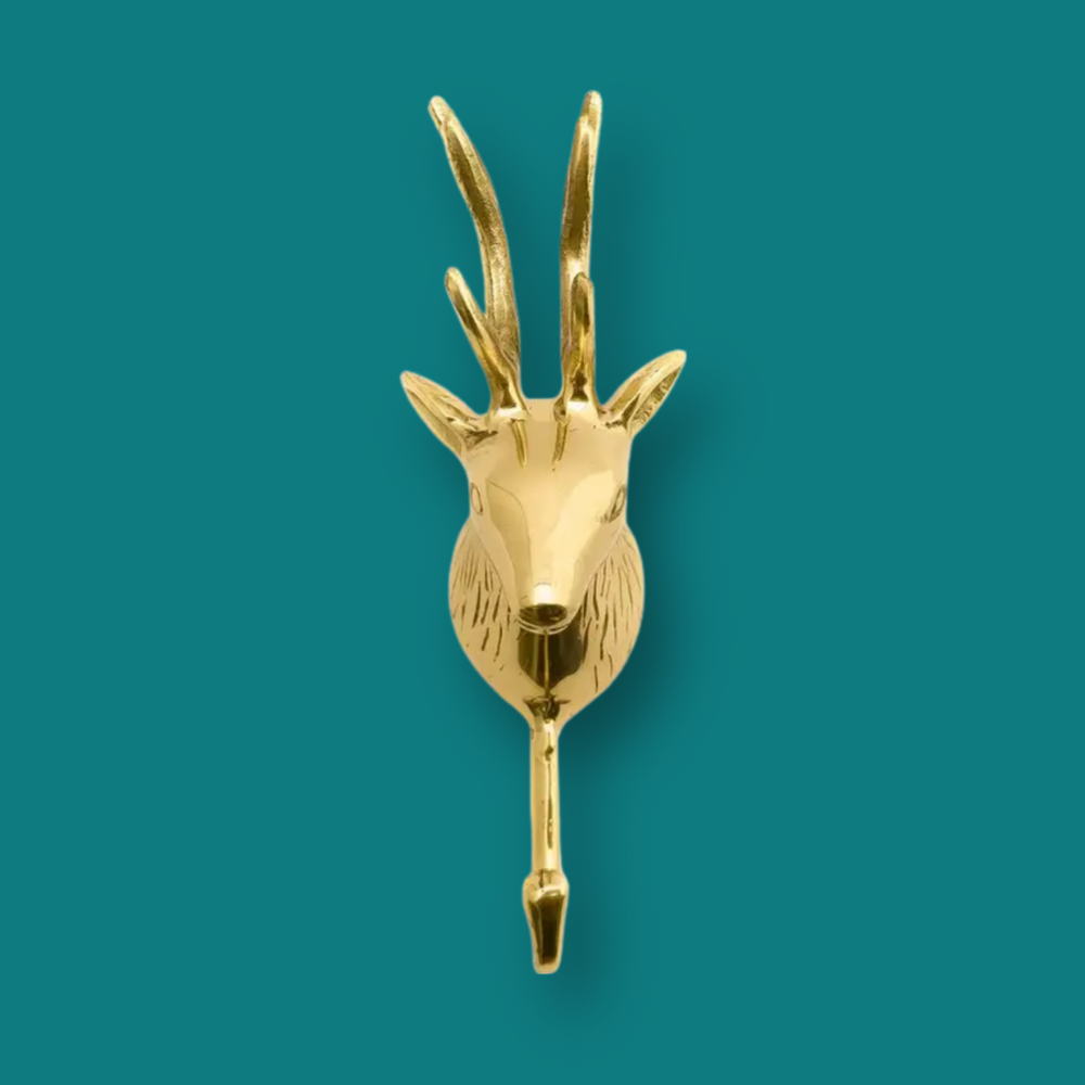 Deer head forest animal coat hook in solid brass hanging on a wall