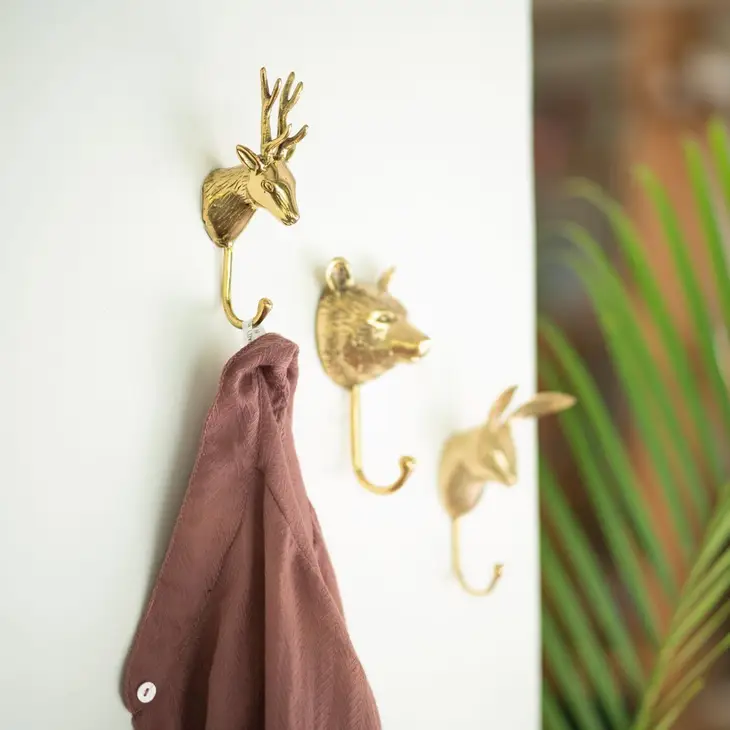 
                  
                    Three forest animal coat hooks- a deer, a bear, and a rabbit- made from solid brass and hanging together on a wall
                  
                