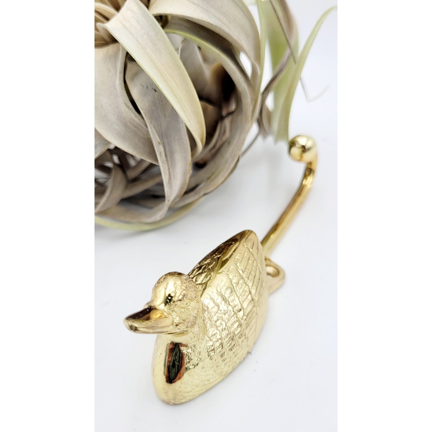 
                  
                    Solid brass swimming gold duck coat hook laying horizontally on the table
                  
                