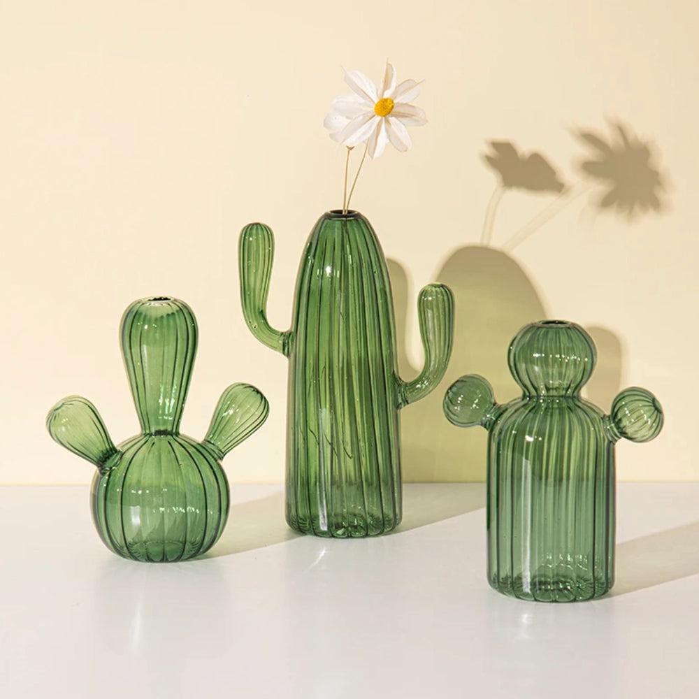 Three vibrant green translucent hydroponic bud vases in the shape of different cactus types