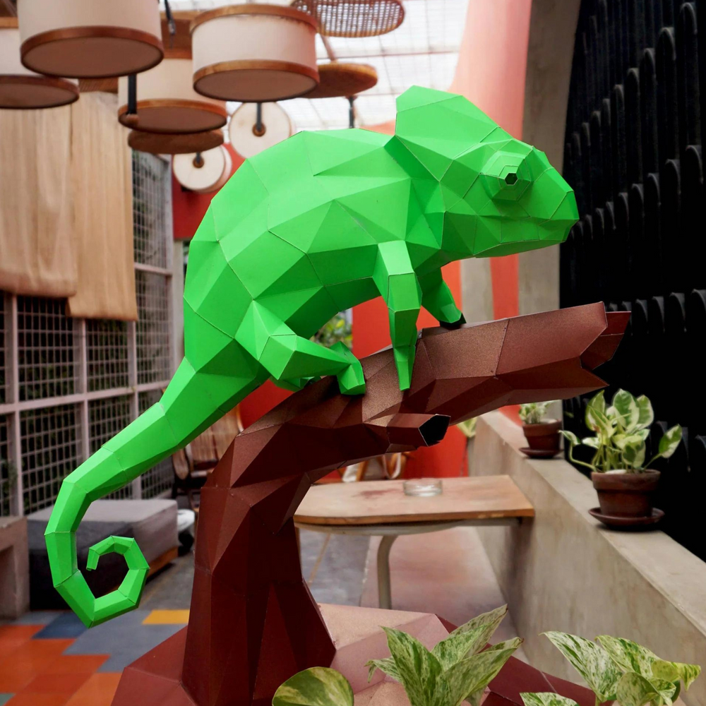 Paper kirigami chameleon on a branch, assembled from a kirigami art for beginners template
