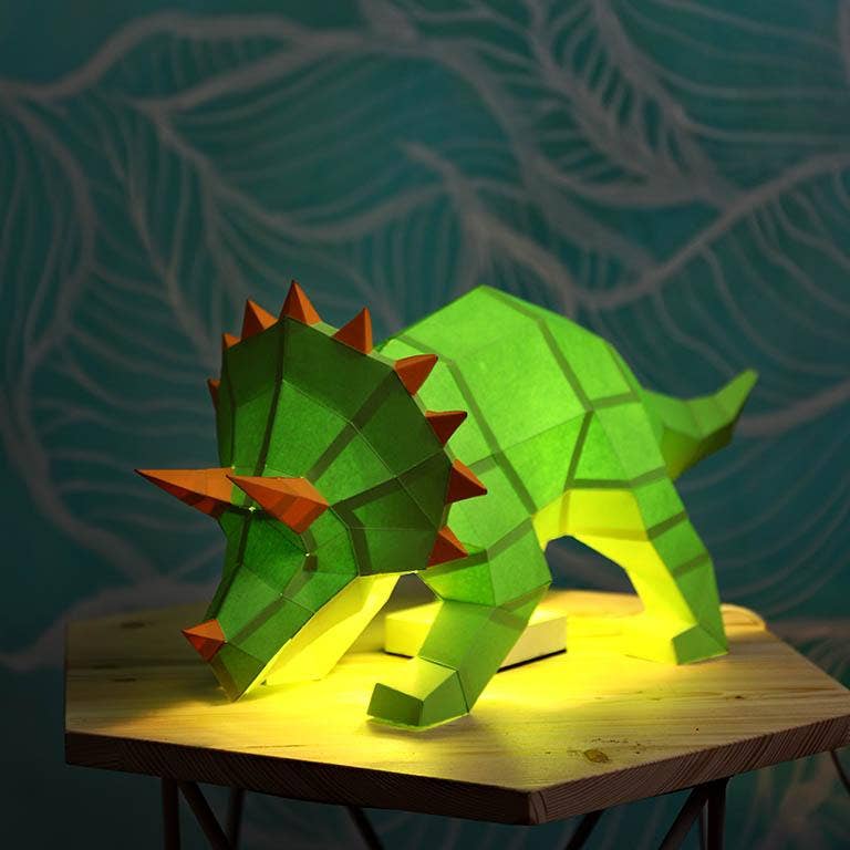 A Kirigami art for beginners table lamp in the shape of a triceratops, made from folded paper