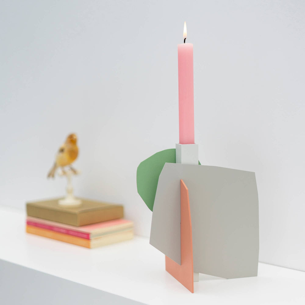 
                  
                    Matisse-inspired pastel metal candlestick holder on a shelf
                  
                