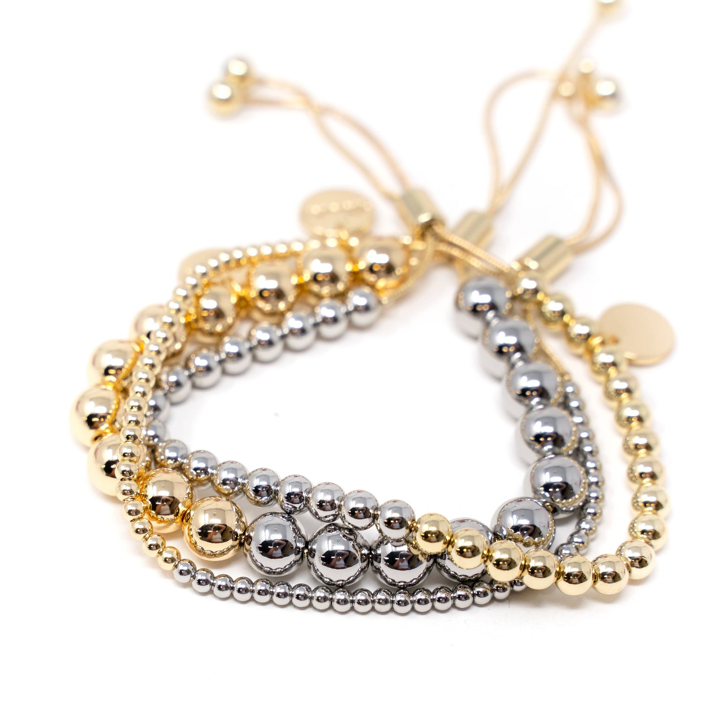 A stack of three two tone adjustable bracelets, with gold and silver beads