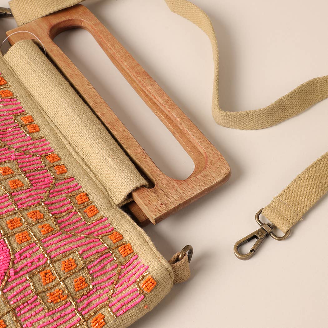 
                  
                    Pink and orange beading detail on "Coral Carnival" wooden handle beaded summer bag. Hardware clasp attached canvas strap to bag.
                  
                