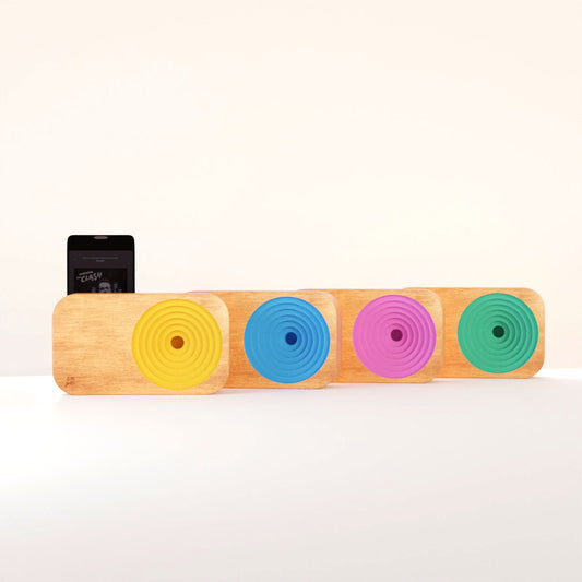 Four wooden sound system blocks which project audio from a cell phone. Colors shown are yellow, blue, pink, and green. 