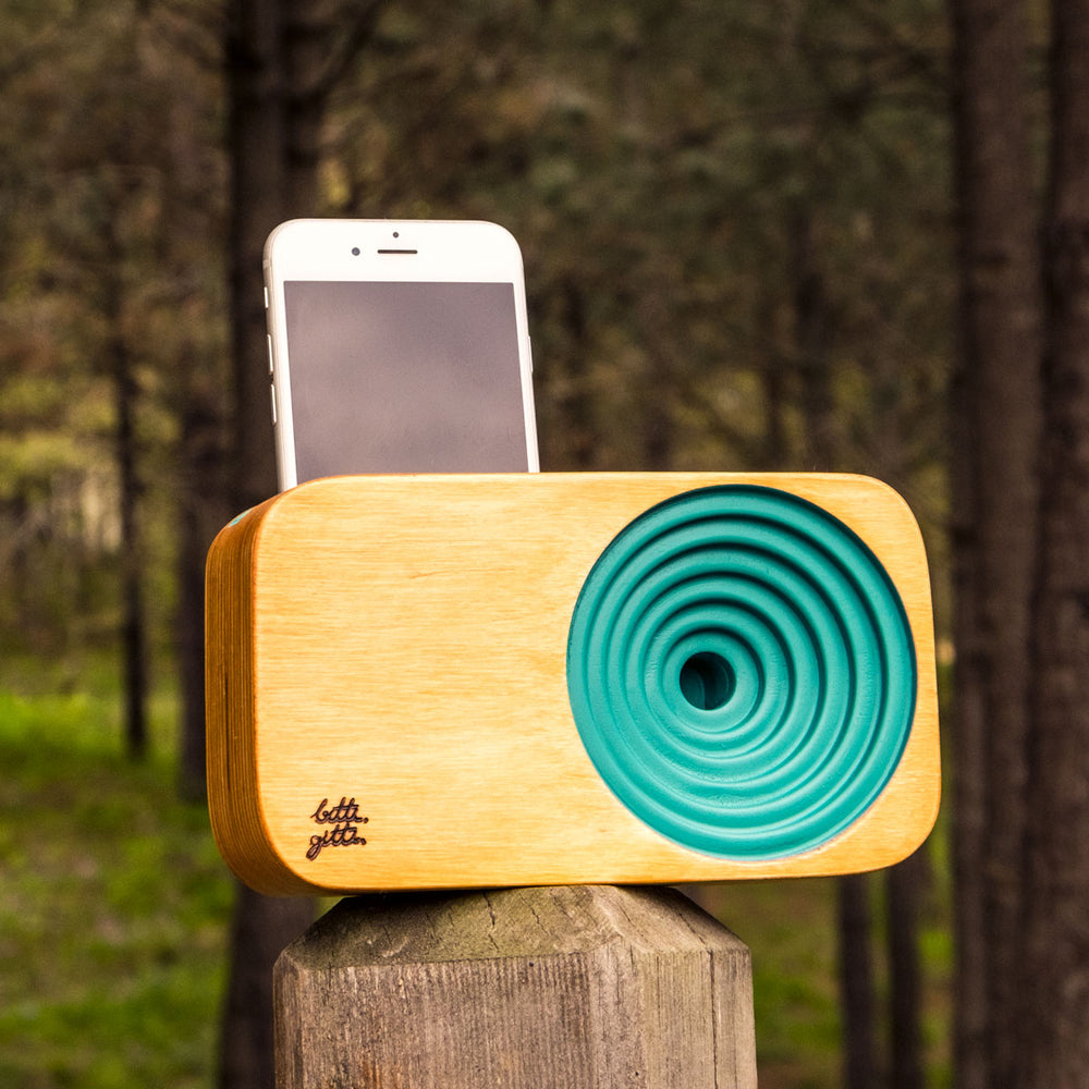 Wooden sound system in turquoise loaded with an iPhone.